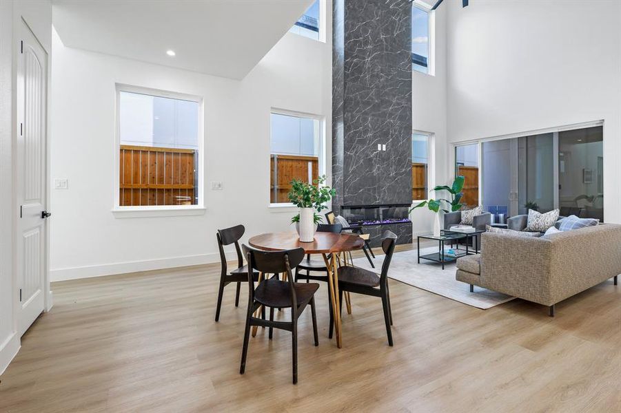 Dining area with light wood-type flooring and a towering ceiling