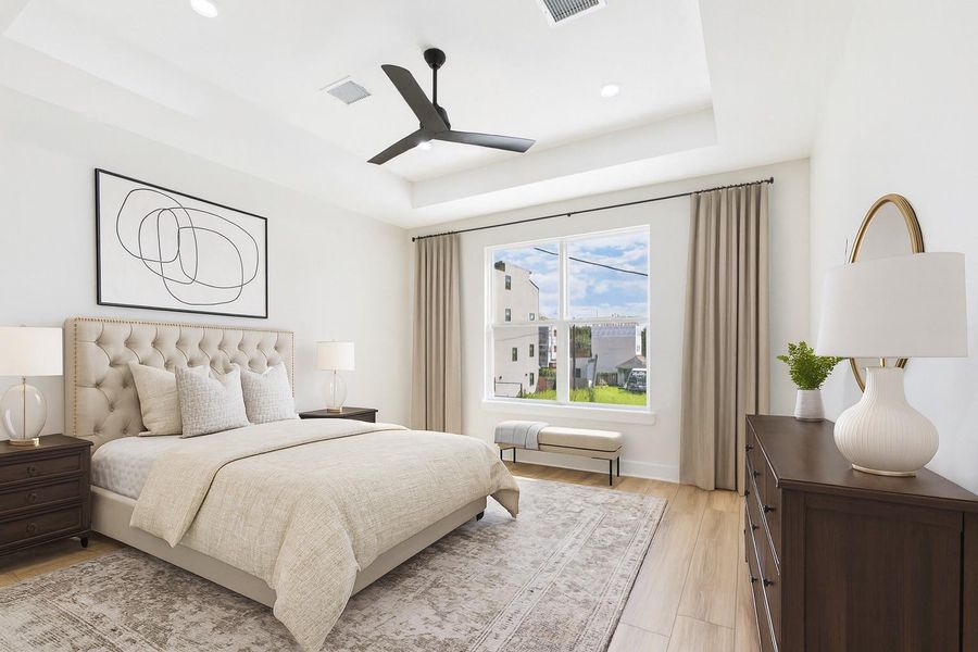 This primary bedroom is bright and airy, featuring a large window with a view, neutral-toned bedding, and elegant furniture. The ceiling fan and modern decor add a touch of sophistication. This photo is virtually staged. This primary bedroom is bright and airy, featuring a large window with a view, neutral-toned bedding, and elegant furniture. The ceiling fan and modern decor add a touch of sophistication. This photo is virtually staged.