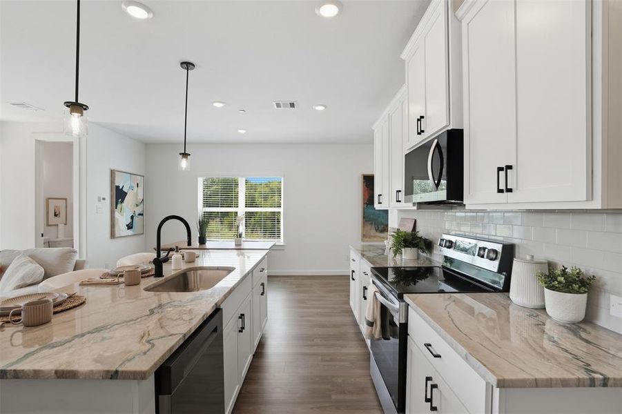 Kitchen featuring appliances with stainless steel finishes, white cabinets, light stone countertops, and recessed lighting Kitchen featuring appliances with stainless steel finishes, white cabinets, light stone countertops, and recessed lighting