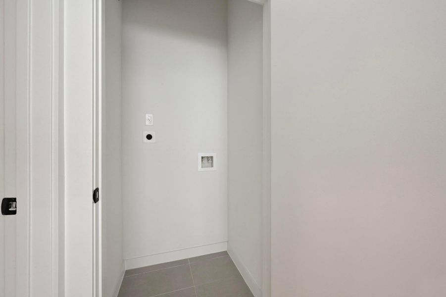 Laundry area featuring washer hookup and tile patterned flooring Laundry area featuring washer hookup and tile patterned flooring