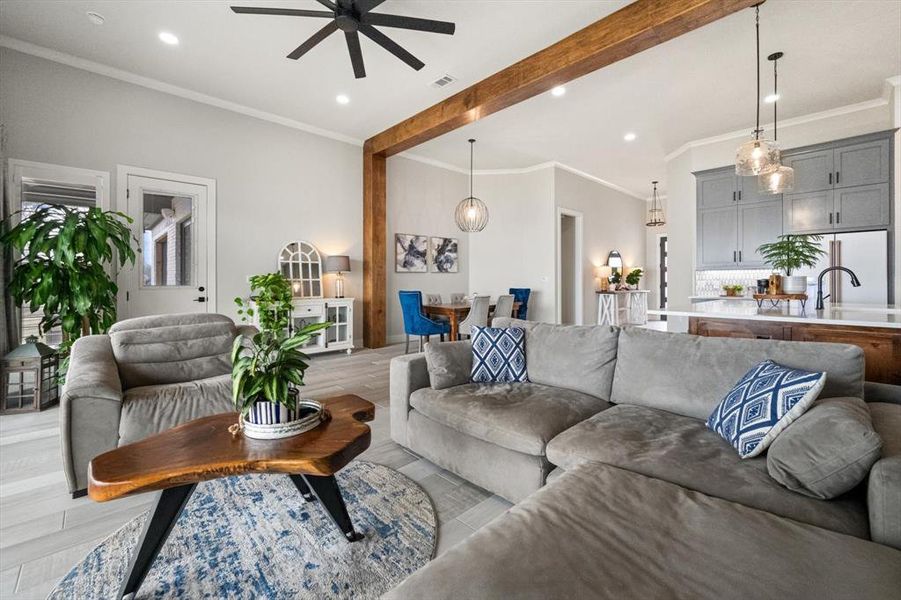 Living area featuring wood beam, designer lighting and large ceiling fan.