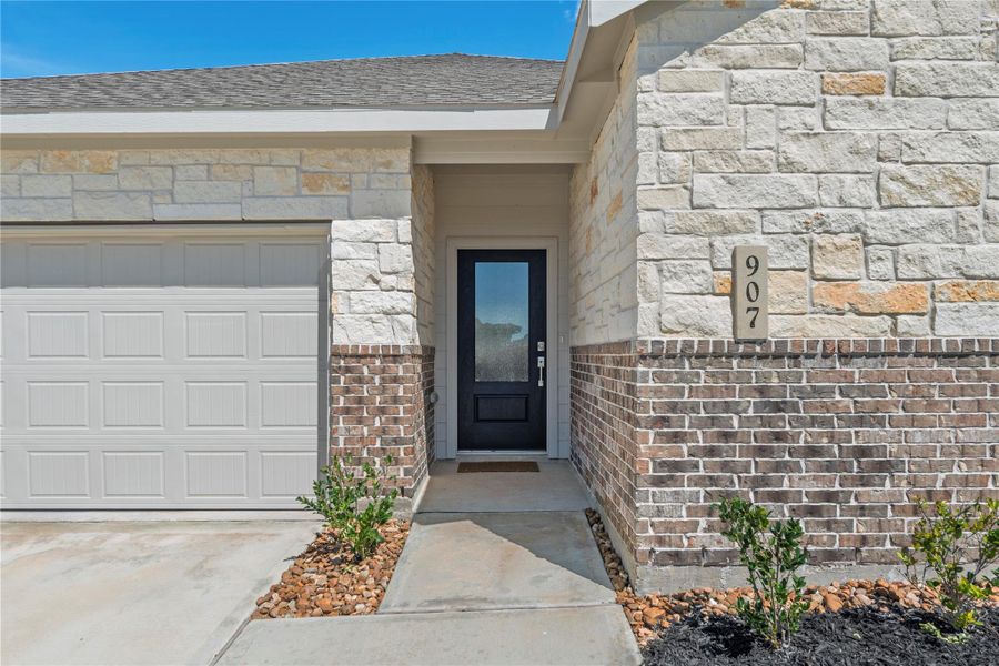 Inviting covered entry with upgraded front door detail.