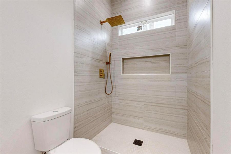 Bathroom with a tile shower and toilet