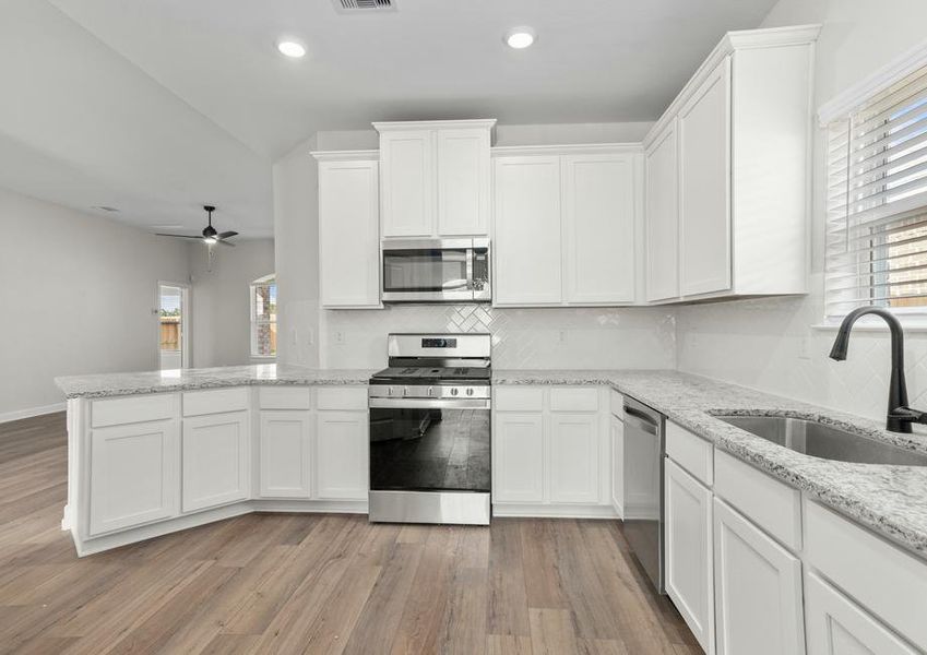 Chef ready kitchen with white cabinets and stainless steel appliances