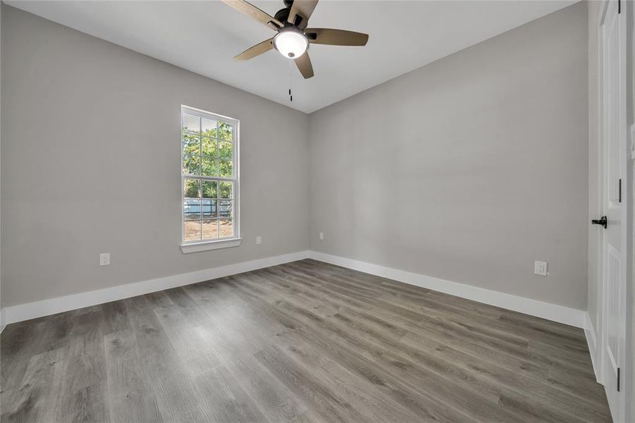 Empty room with ceiling fan and hardwood / wood-style flooring