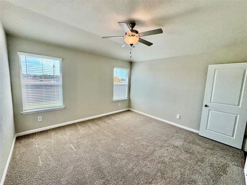 Unfurnished bedroom with a textured ceiling, carpet flooring, and a ceiling fan Unfurnished bedroom with a textured ceiling, carpet flooring, and a ceiling fan
