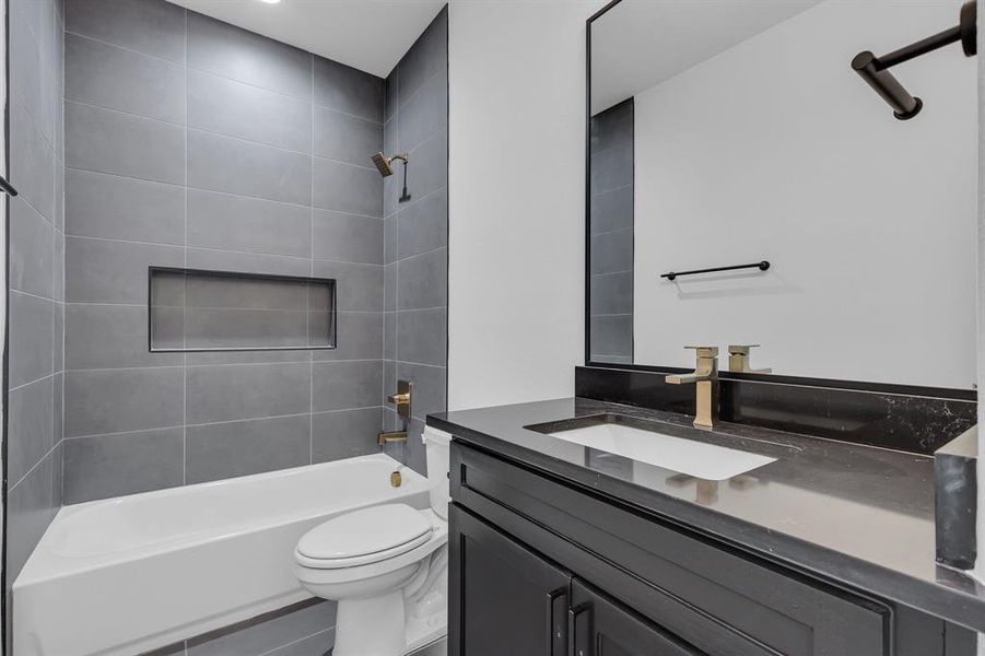 Full bathroom featuring vanity, toilet, and tiled shower / bath combo