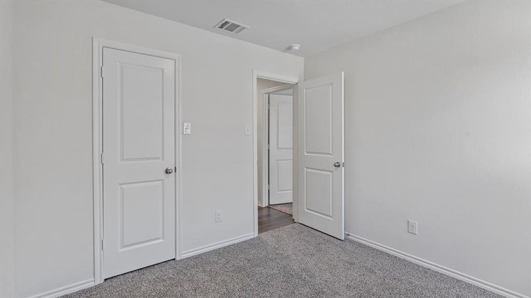 Unfurnished bedroom with dark carpet and baseboards Unfurnished bedroom with dark carpet and baseboards