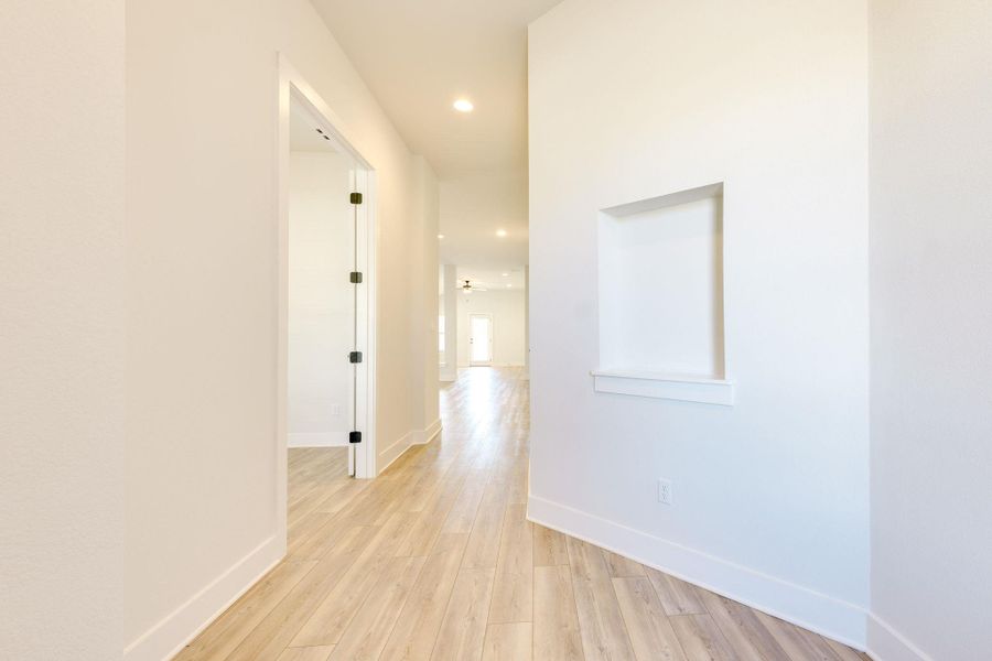 Hall with light wood-style flooring and recessed lighting