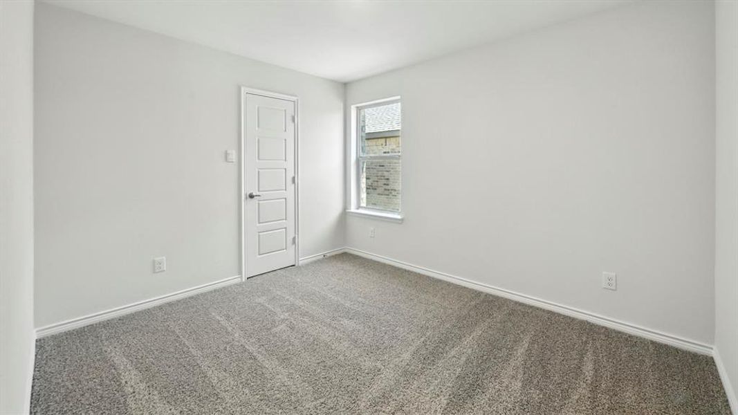 Spare room featuring carpet floors and baseboards