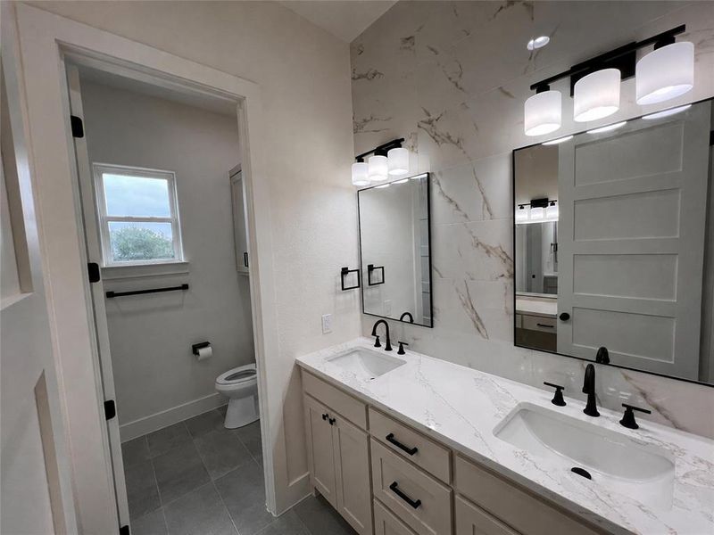 Double vanity featuring undermount sinks, white countertops, and matte black fixtures