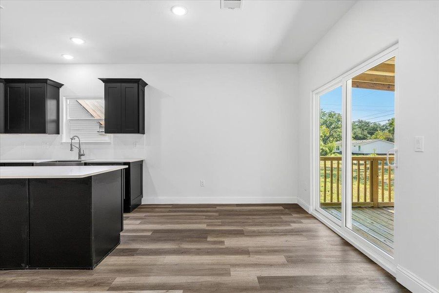 Sliding glass doors open from the modern dining space to a wooden back deck. Sliding glass doors open from the modern dining space to a wooden back deck.
