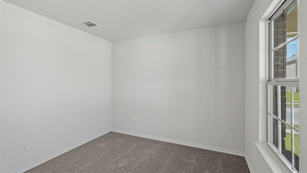 Interior room featuring neutral wall paint, grey carpet flooring, and a single pane window with white trim