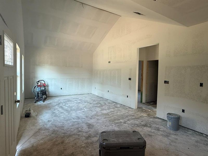 Bonus room with concrete flooring and high vaulted ceiling