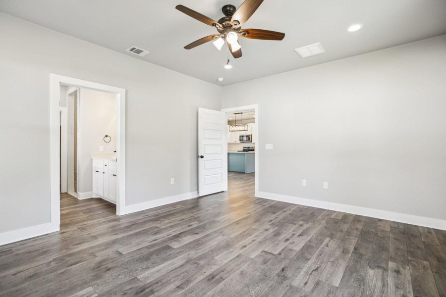 Unfurnished bedroom with wood finished floors, recessed lighting, ceiling fan, and ensuite bathroom