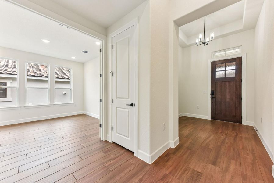 Entryway featuring wood finished floors and a chandelier