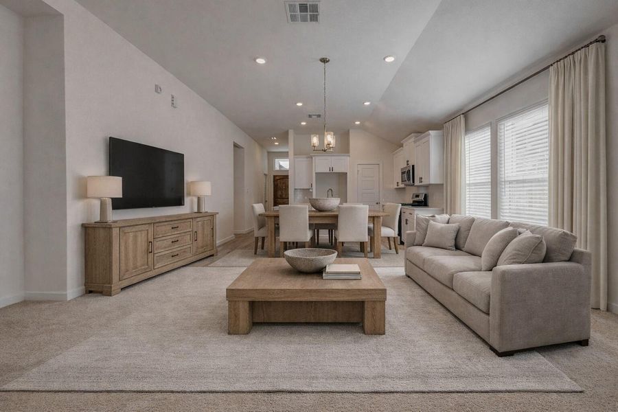 This stunning open-concept space seamlessly connects the kitchen and living areas with expansive sightlines, soft neutral tones, and large windows that draw in natural light. Vaulted ceilings with recessed lighting add volume, while plush carpeting transitions effortlessly into wood-look tile, creating the perfect blend of comfort and style. This photo has been virtually staged for visual reference.