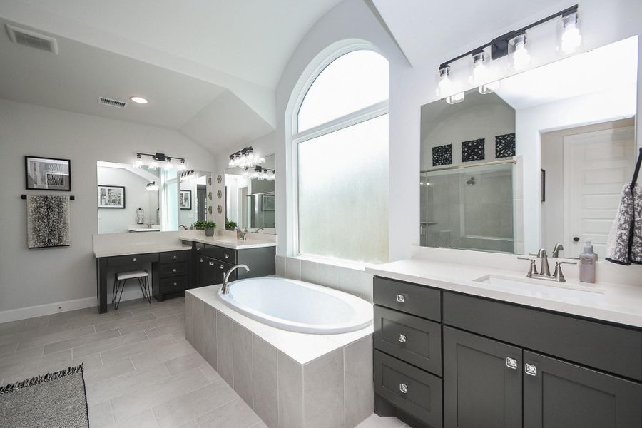 Ensuite has 24x12 tile, separate vanities, and oversized soaking tub