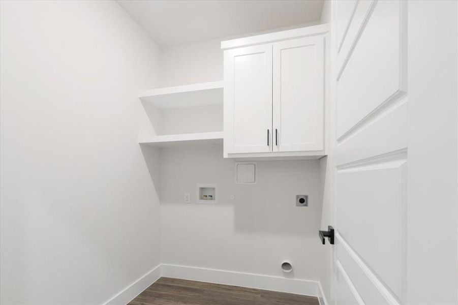 Laundry area featuring dark wood-type flooring, hookup for a washing machine, cabinets, and electric dryer hookup