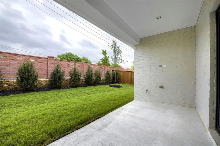 The property features a covered patio with a white brick exterior, overlooking a well-maintained lawn