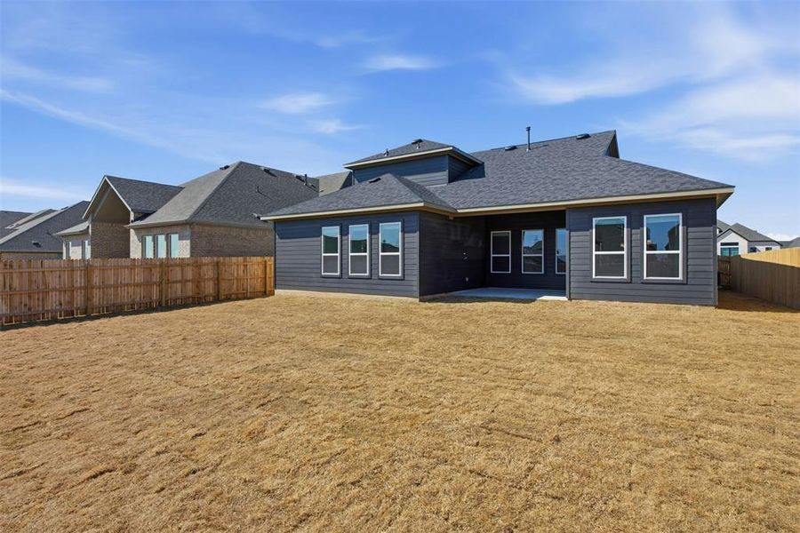 Expansive backyard with a full wood fence and a concrete patio