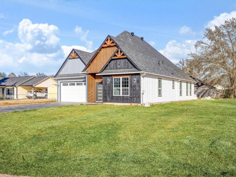 View of front of property with a front lawn, driveway, an attached garage, and a shingled roof View of front of property with a front lawn, driveway, an attached garage, and a shingled roof