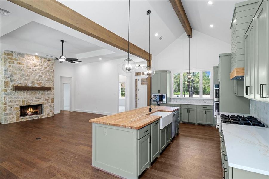 Kitchen featuring decorative light fixtures, open floor plan, healthy amount of natural light, butcher block counters, and recessed lighting Kitchen featuring decorative light fixtures, open floor plan, healthy amount of natural light, butcher block counters, and recessed lighting