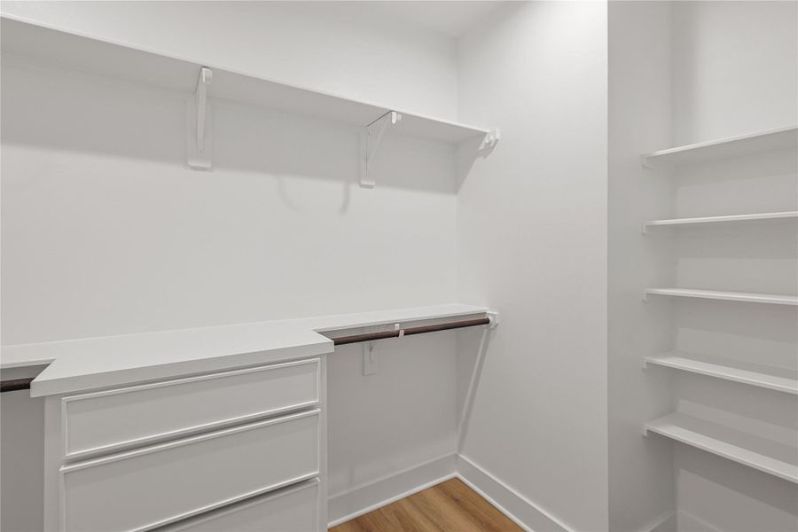 Discover the spacious primary closet, thoughtfully designed with custom built-in shelving and drawers to keep your wardrobe perfectly organized. This luxurious and functional space adds a touch of elegance to your daily routine, you’ll love having this much room to call your own.