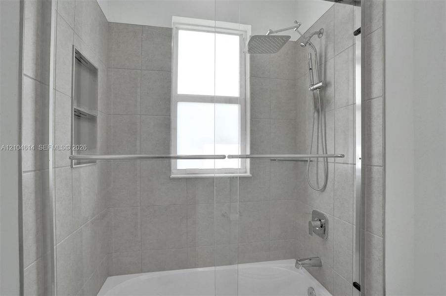 Bathtub with tile surround, built-in shower niche, and multi-function showerhead