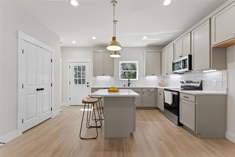 Warm oat-colored cabinetry, marble-look stone countertops, and a beautiful window above the sink overlooking the deck, backyard, and greenspace beyond. Open and bright with generous cabinet storage,a large pantry,plus an island for enjoying friends and family while you cook.