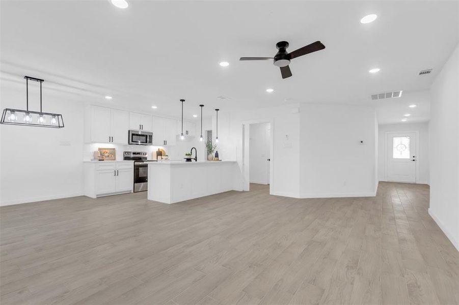 Unfurnished living room featuring recessed lighting, ceiling fan, and light wood-style flooring