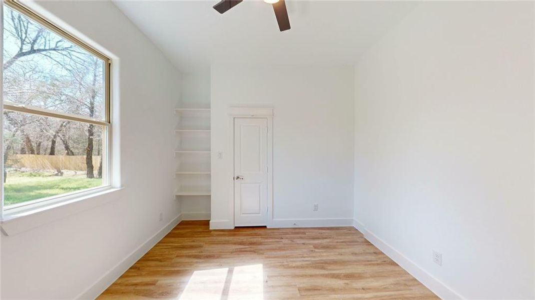 Unfurnished bedroom with ceiling fan, light wood-type flooring, and baseboards