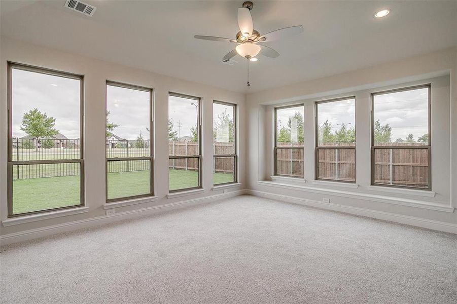 Carpeted empty room featuring ceiling fan