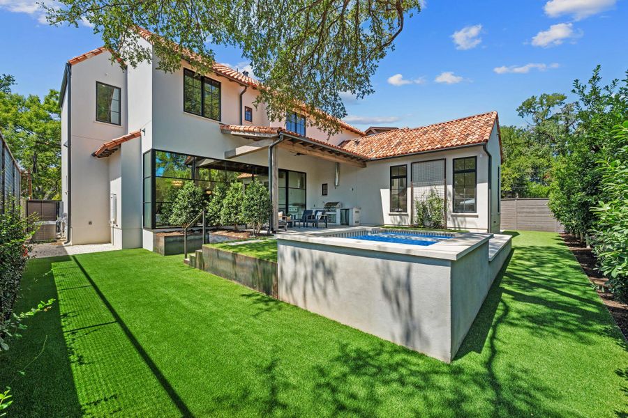 Spanish tile roofs and plaster walls frame a custom plunge pool in the rear yard.