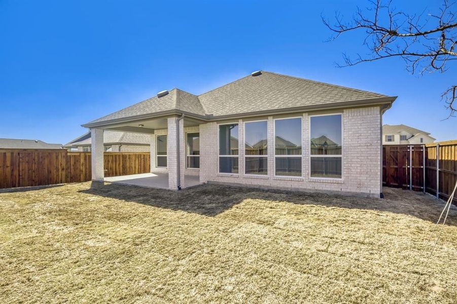 Back of property featuring roof with shingles, a patio, a fenced backyard, and brick siding