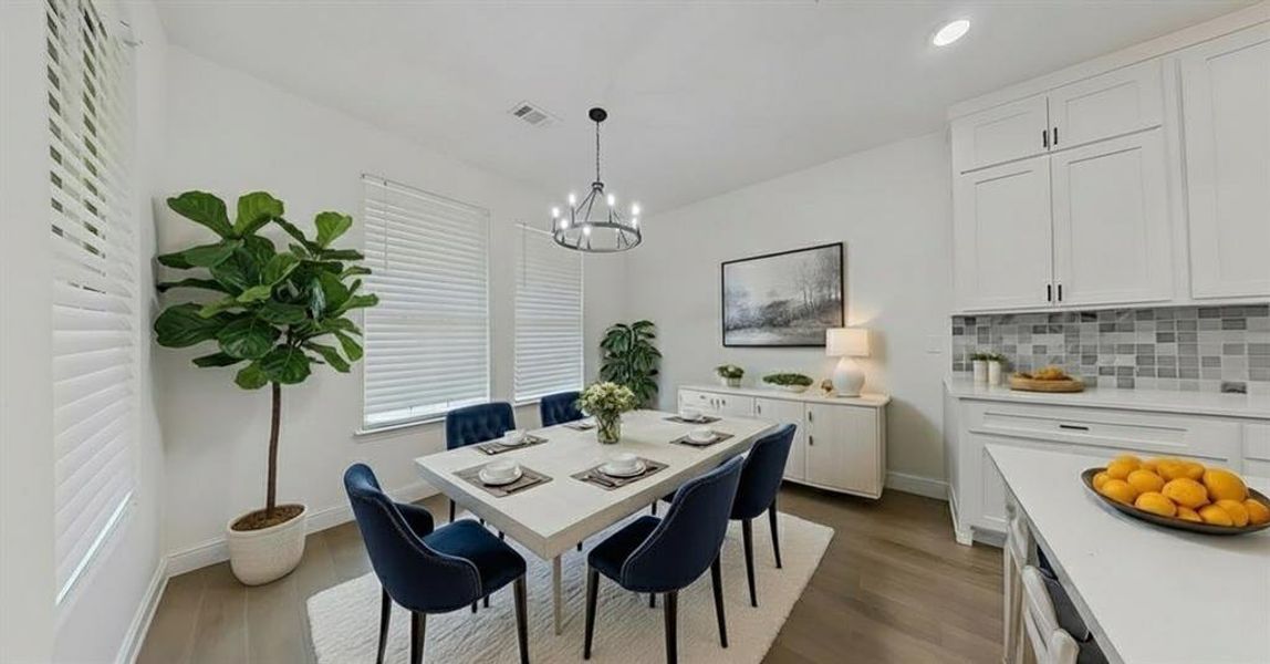 Dining space featuring dark wood-style floors, a chandelier, and recessed lighting