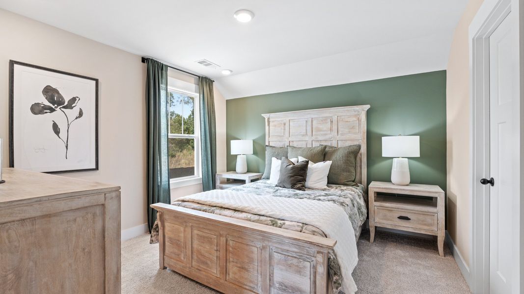 Tasteful secondary bedroom with plush carpet and a spacious walk-in closet at the new Barton Hollow community
