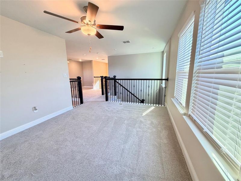 Carpeted spare room with baseboards and ceiling fan Carpeted spare room with baseboards and ceiling fan