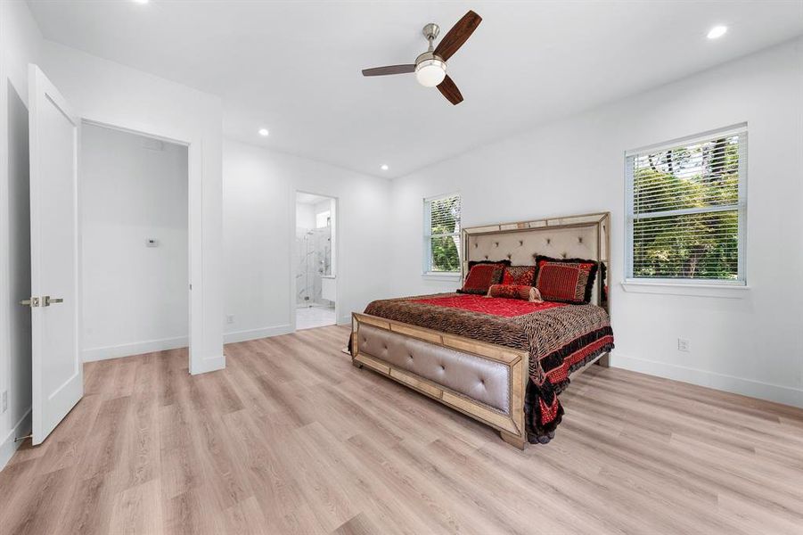 Bedroom with recessed lighting, light wood finished floors, ceiling fan, and connected bathroom Bedroom with recessed lighting, light wood finished floors, ceiling fan, and connected bathroom