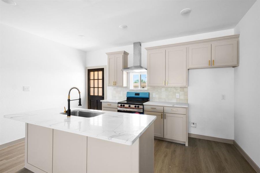 Kitchen featuring electric range, wall chimney exhaust hood, a sink, and light wood-type flooring Kitchen featuring electric range, wall chimney exhaust hood, a sink, and light wood-type flooring