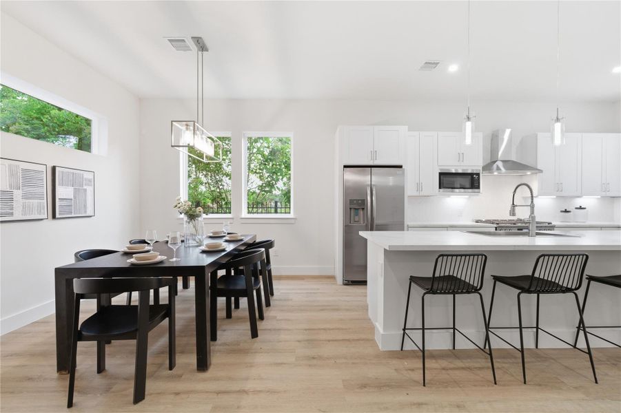 Framed by natural light and backyard views, the dining area and kitchen come together in a bright, open setting that enhances both daily living and entertaining.