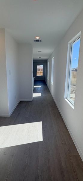 Corridor with baseboards and dark wood-type flooring Corridor with baseboards and dark wood-type flooring
