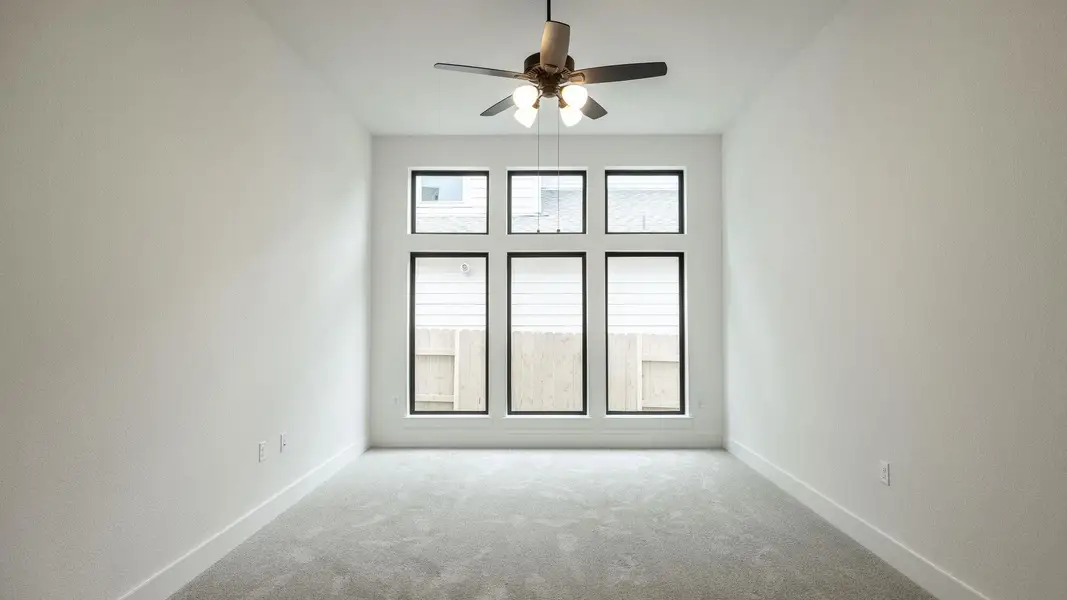 Carpeted spare room featuring ceiling fan and baseboards Carpeted spare room featuring ceiling fan and baseboards