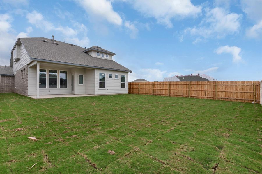 Rear view of property with a patio area, a fenced backyard, and roof with shingles