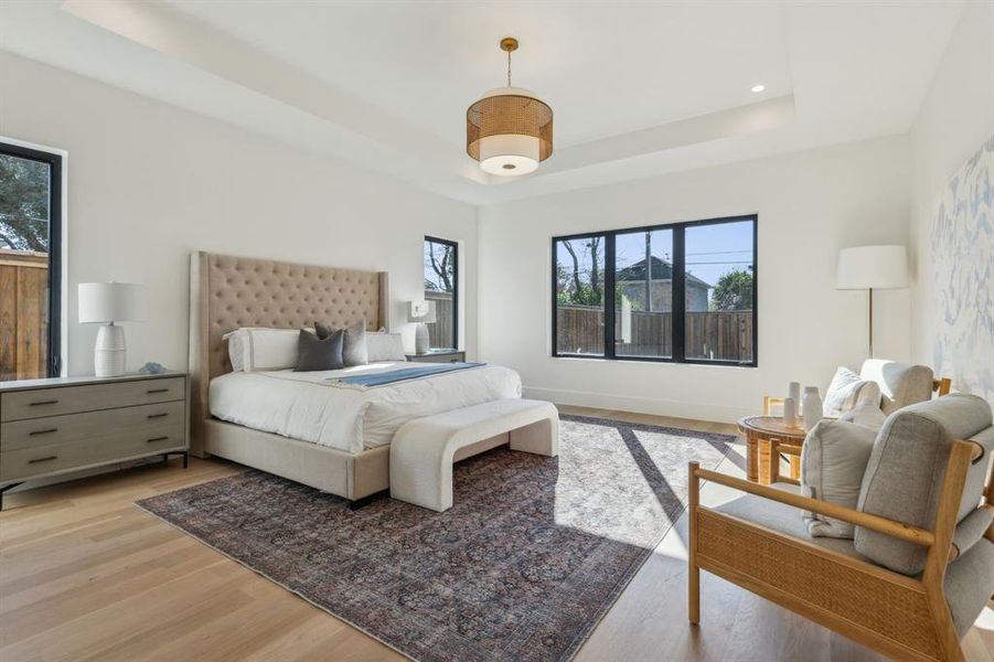 Bedroom featuring a raised ceiling and light hardwood / wood-style floors