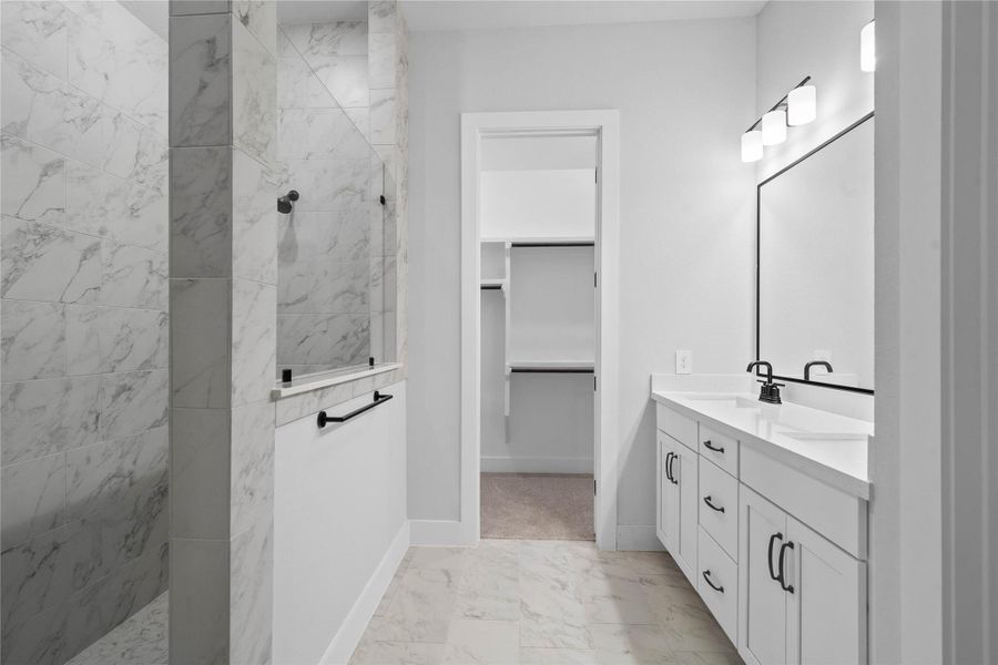 A bright and functional primary bath offering dual sinks for busy mornings, a large framed mirror, and a modern super walk-in shower, creating a serene and efficient space. A bright and functional primary bath offering dual sinks for busy mornings, a large framed mirror, and a modern super walk-in shower, creating a serene and efficient space.