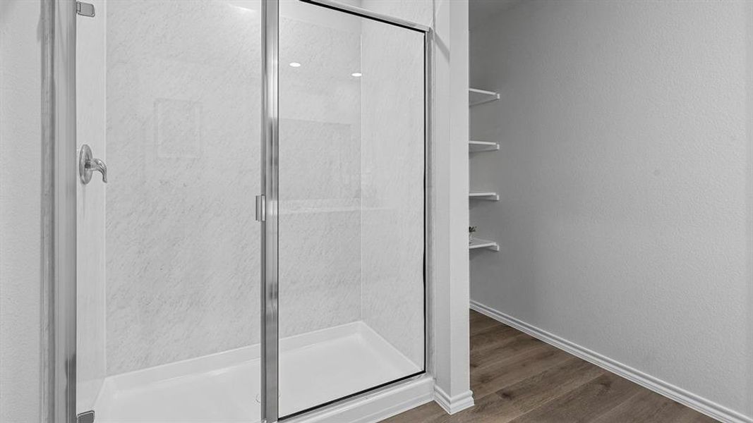 The property features a shower with glass enclosure, white shower base, and a tiled shower surround
