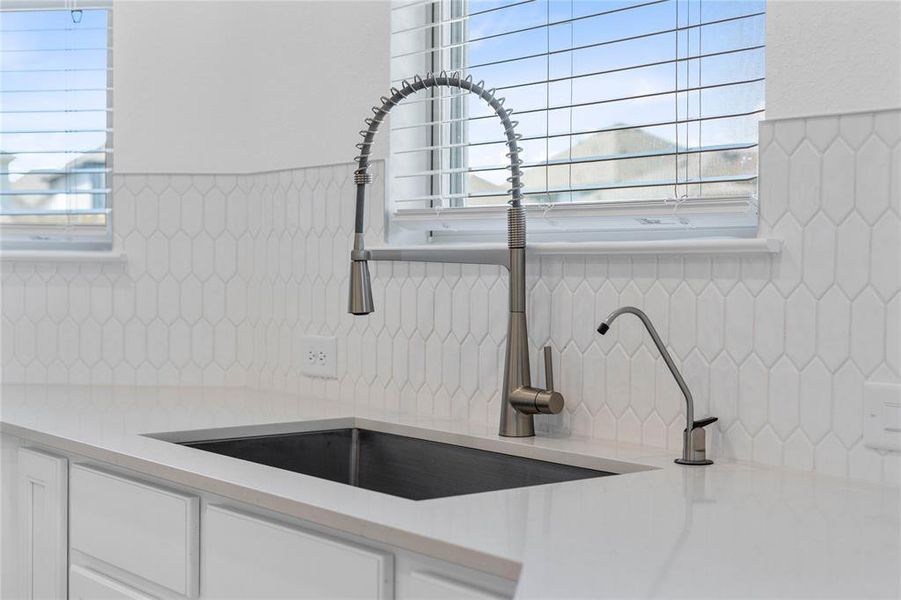 Featured here is the Moen Sleek Spring Kitchen Faucet placed here in the self-rimming single bowl kitchen sink. This gorgeous backsplash is Daltile Artezen in Elegant White.