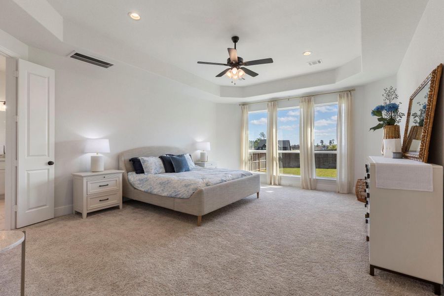 Spacious and bright primary bedroom with large windows offering scenic views, creating a serene and inviting atmosphere.