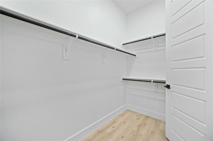Walk in closet with light wood finished floors Walk in closet with light wood finished floors